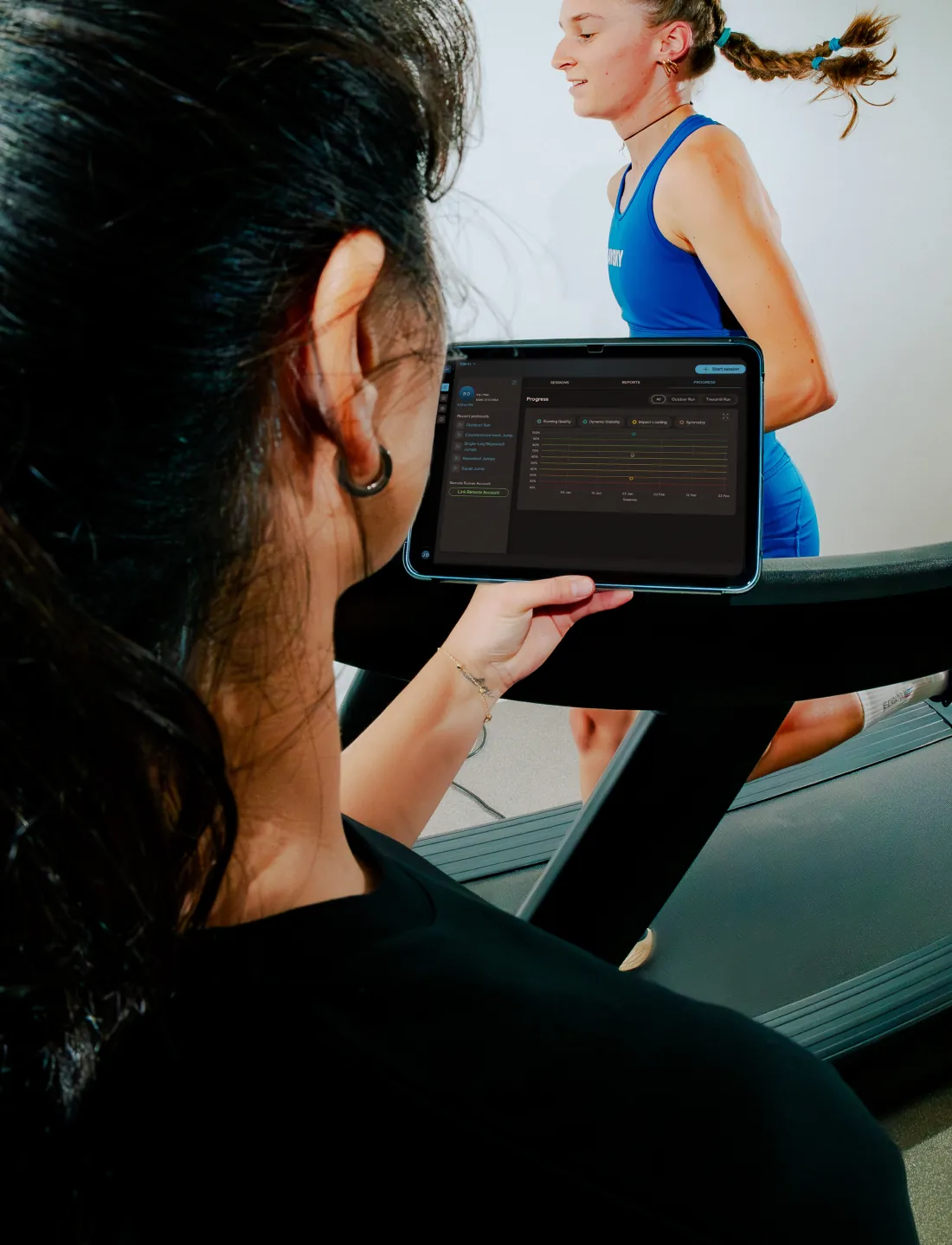 Seen over a tester's shoulder: a tablet with live Runeasi data while a runner runs on a treadmill
